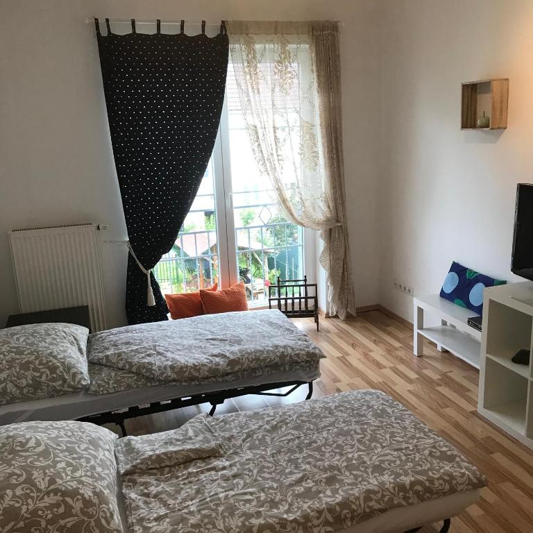 - un salon avec deux lits et une fenêtre dans l'établissement LG living Apartment, à Stockerau
