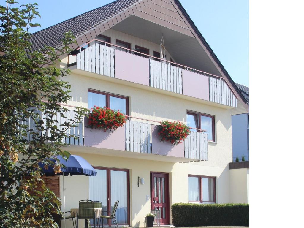 uma casa com uma varanda com flores em Ferienwohnung Haus Wannenberg em Tengen