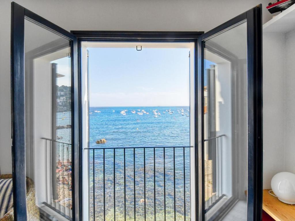 a room with a balcony with a view of the ocean at Exclusive front line apartment in Calella de Palafrugell