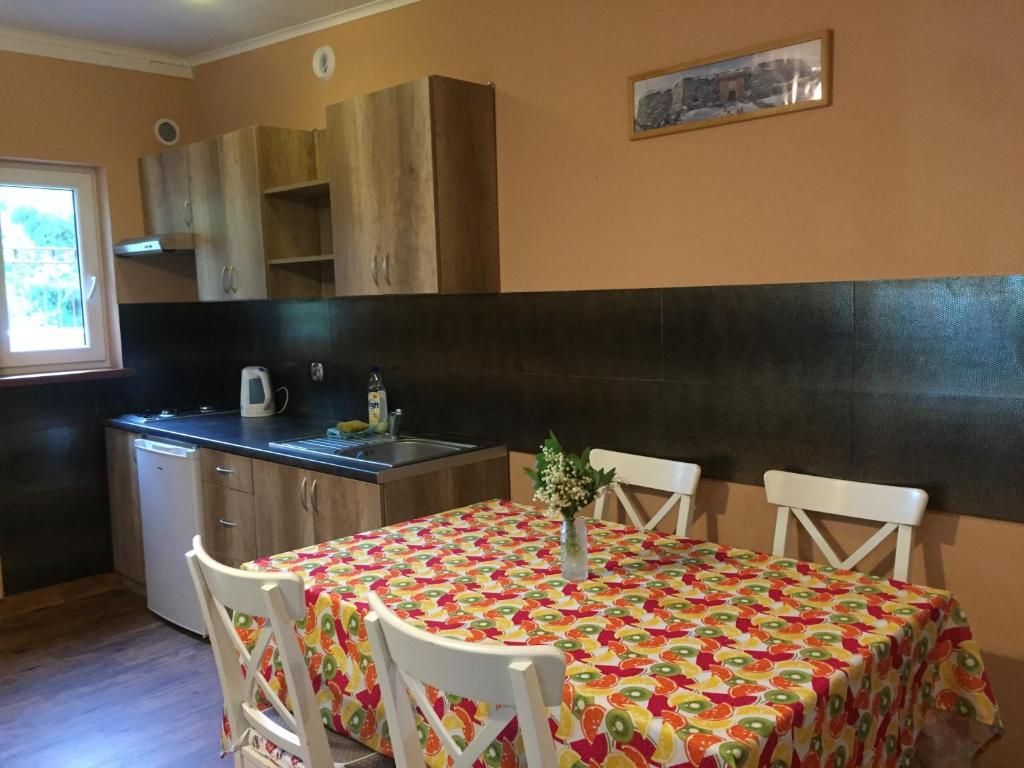 a kitchen with a table with a table cloth on it at Domek pod świerkami 1 in Skorzęcin