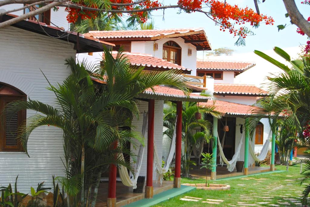 una casa con palmeras delante en Paracuru Kite Village, en Paracuru