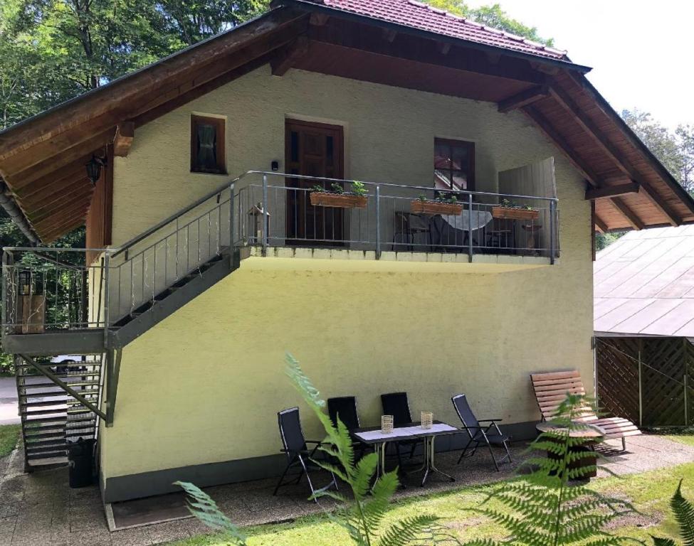 een huis met een balkon en een tafel en stoelen bij Ferienhäuser Geiersberg in Hauzenberg