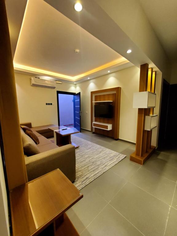 a living room with a couch and a television at Passion Hotel Villas in Khamis Mushayt