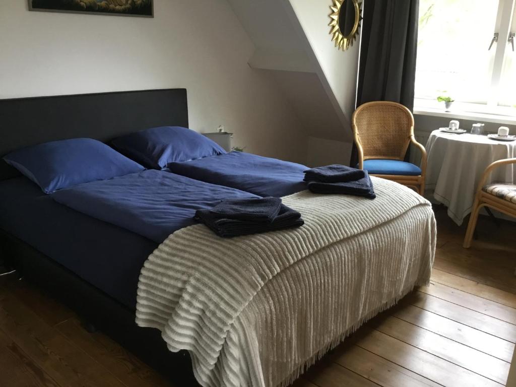 a bed with blue sheets and blue pillows on it at La Casa aan Zee in Ellemeet