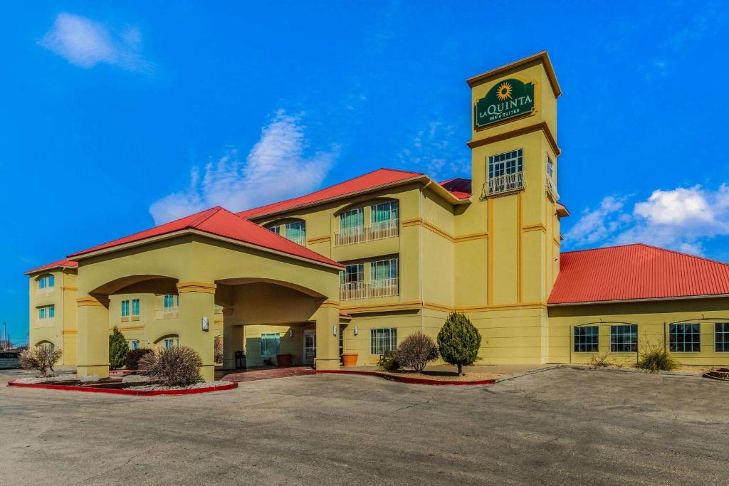 a yellow building with a sign on top of it at La Quinta by Wyndham Hobbs in Hobbs