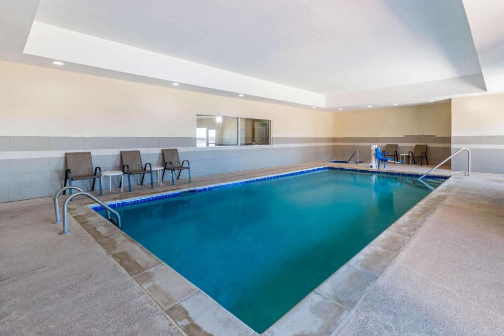 a pool in a hotel with chairs around it at La Quinta by Wyndham Artesia in Artesia