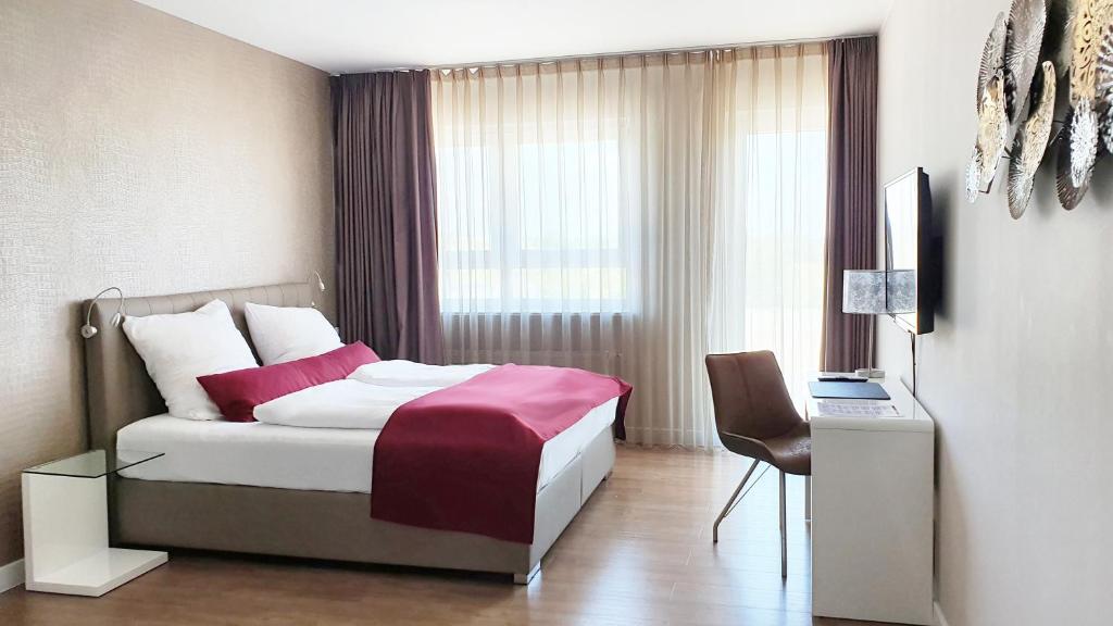 a hotel room with a bed and a window at TH39 Trend Hotel in Bad Vilbel