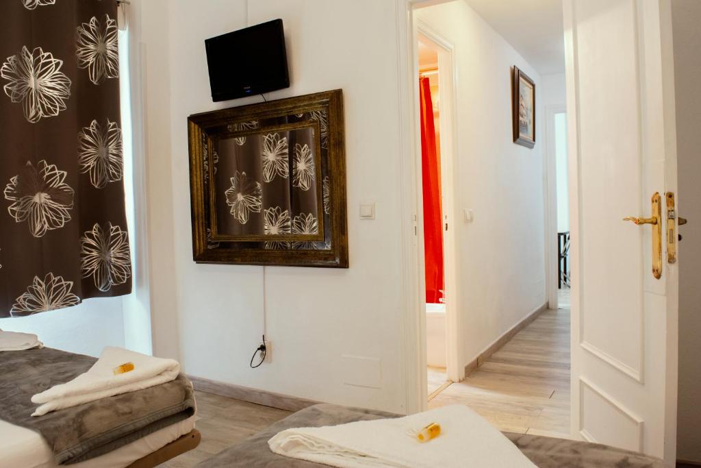 Habitación con cama y TV en la pared. en Apartamentos Sleep in Madrid, en Madrid