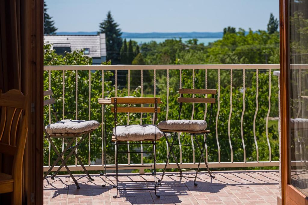two chairs and a table on a balcony at Balaton Vendégház in Balatonfüred