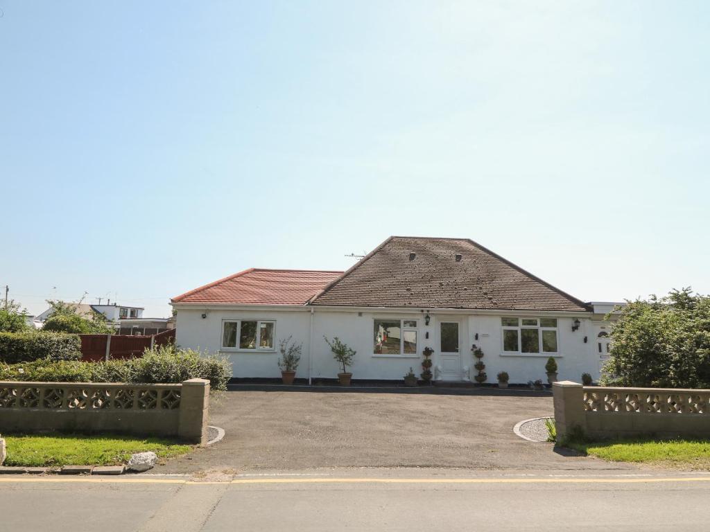 een wit huis met een bruin dak bij Beachway in Holywell