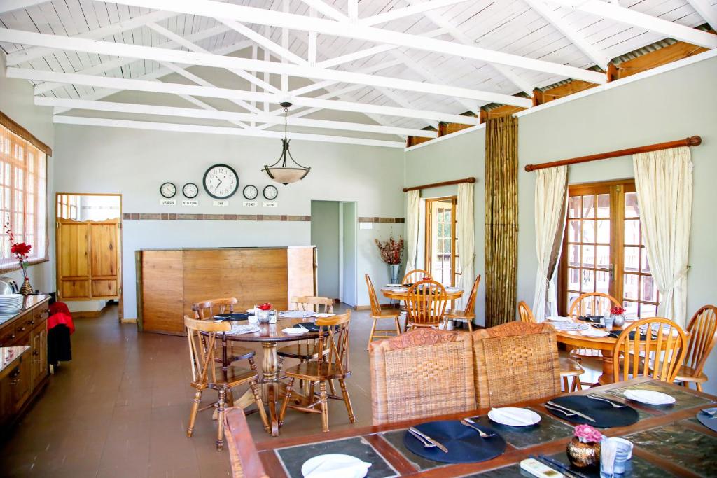 een woonkamer met houten tafels en stoelen bij Hardekool Guesthouse in Thabazimbi