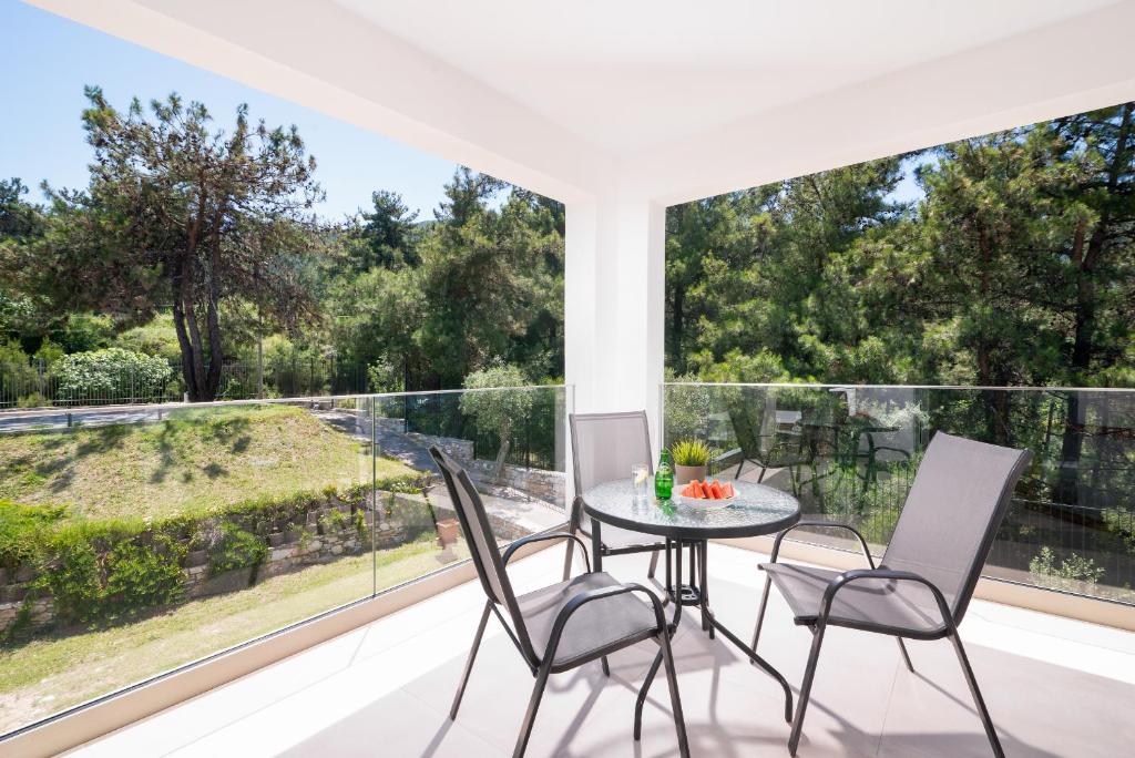 a dining room with a table and chairs on a balcony at Villa Victoria by La Scala Beach in Limenas