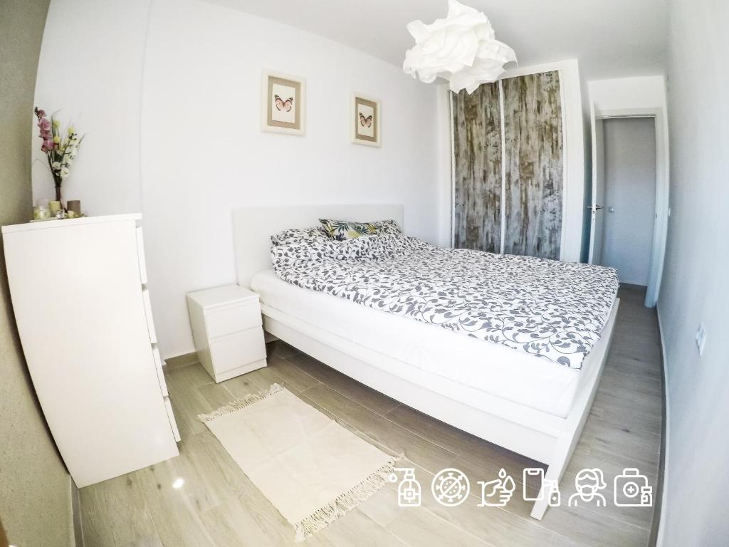 ベナルマデナにあるCasa de Mariposasの白いベッドルーム(ベッド1台、鏡付)