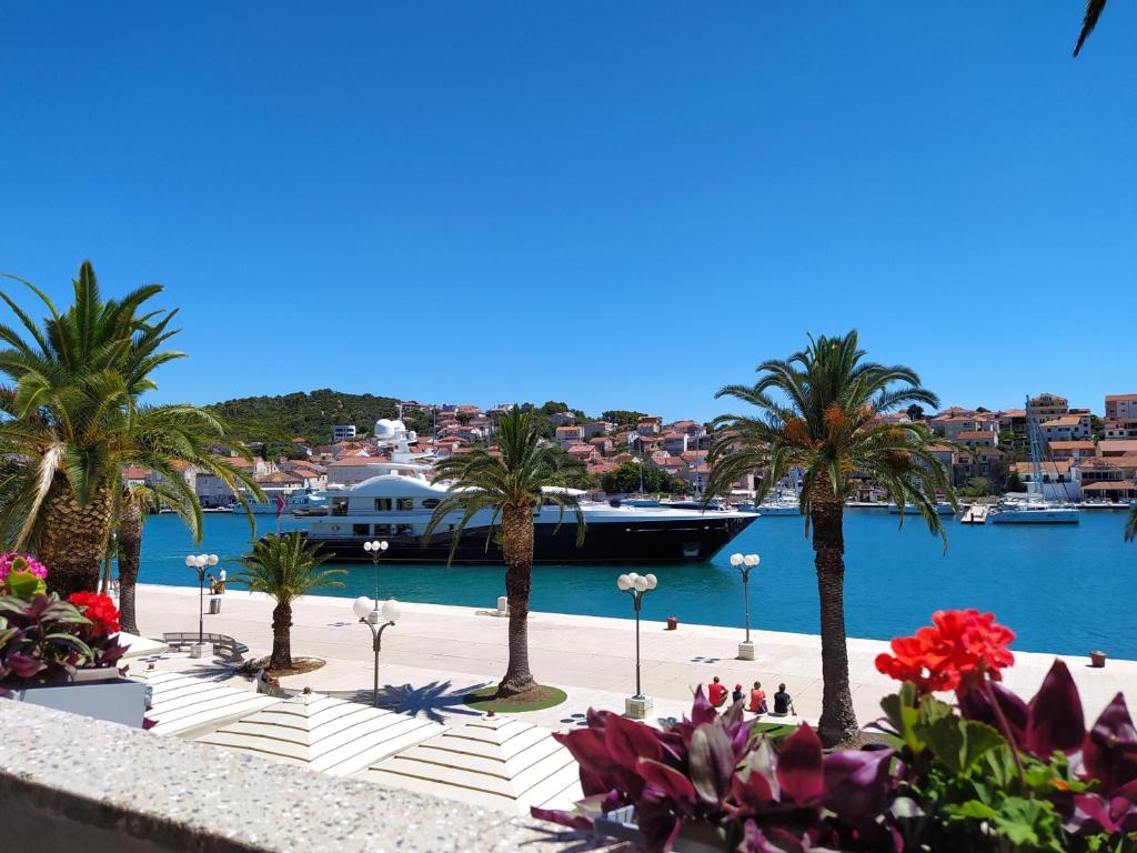 - une vue sur un port avec des palmiers et un bateau dans l'établissement Apartment Stella old town Trogir, with balcony, à Trogir
