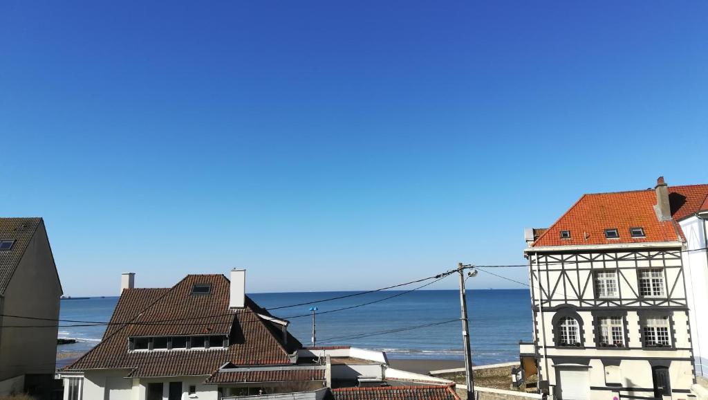 eine Gruppe von Gebäuden mit dem Ozean im Hintergrund in der Unterkunft Appartement l'Estivalière face à la mer in Wimereux