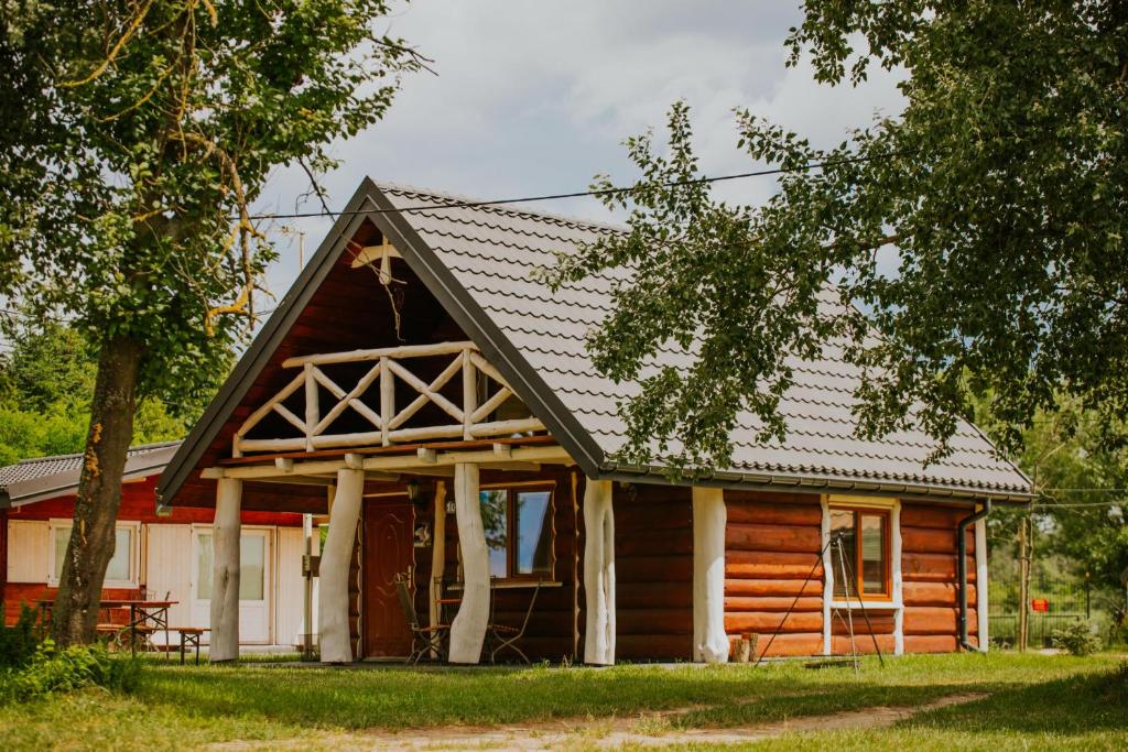 uma cabana de madeira com um telhado de gambrel em Wioska Rybacka Wilga em Wilga