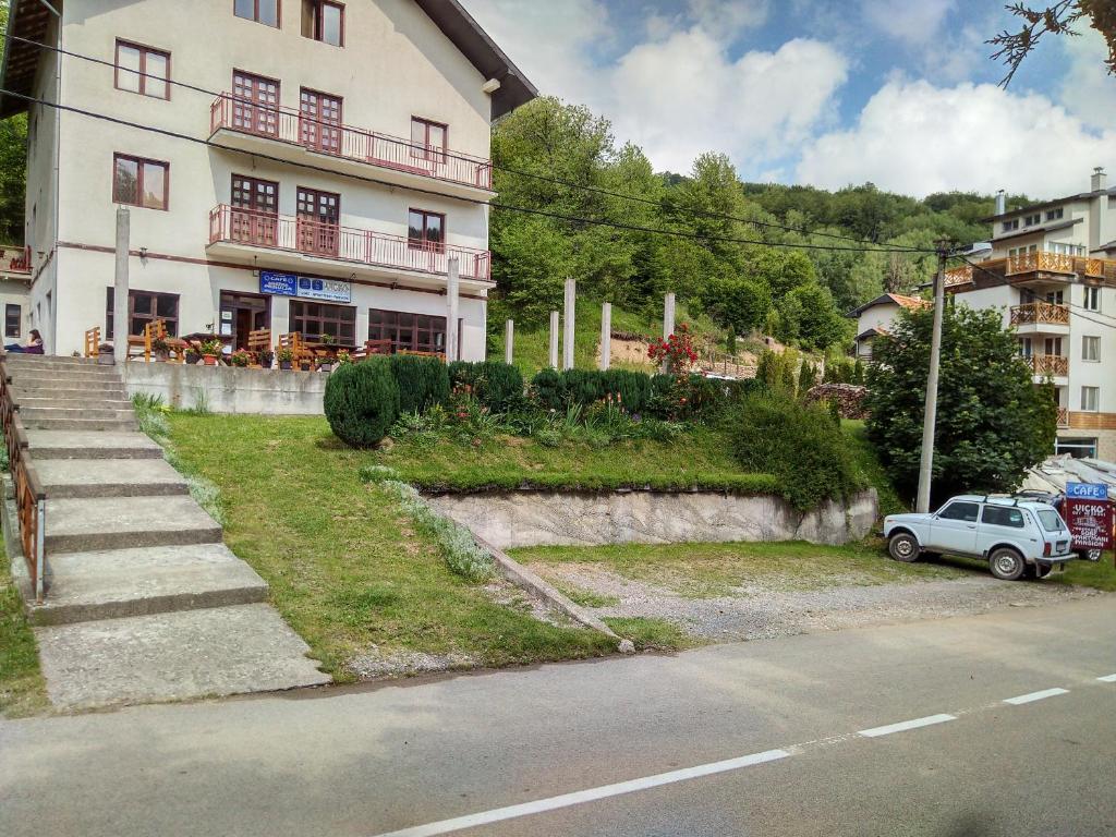 un pequeño coche aparcado frente a un edificio en Apartments and Rooms Vicko, en Brzeće