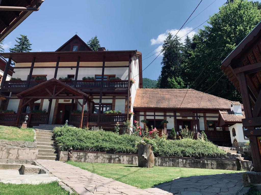 a large house with a porch and stairs to it at Székely Fogadó - Hanul Secuiesc in Băile Tuşnad