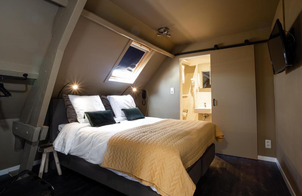 安特衛普的住宿－Hotel1875，一间卧室设有一张床、一个窗口和一台电视