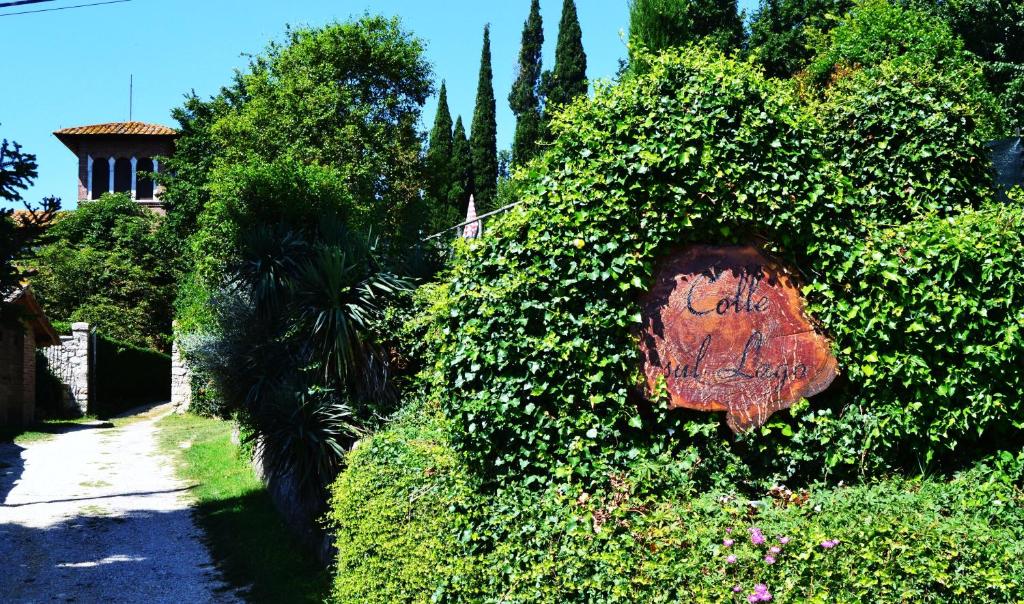 un arbusto con un cartel en el costado de una casa en Colle sul Lago, en Castiglione del Lago