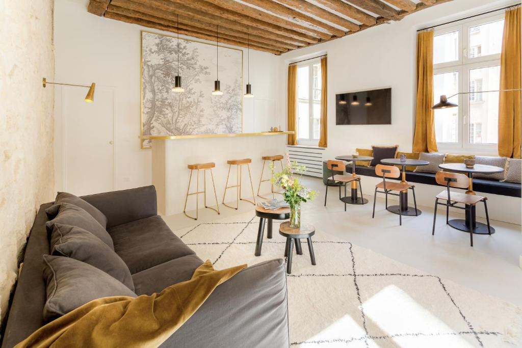 un salon avec un canapé et une table dans l'établissement Habitat Parisien - 2BR-2BA - Marais - Hôtel de Ville, à Paris