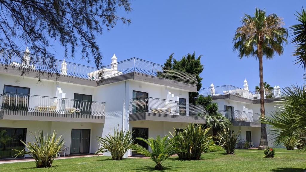 an apartment building with balconies and palm trees at Bayside Salgados in Albufeira