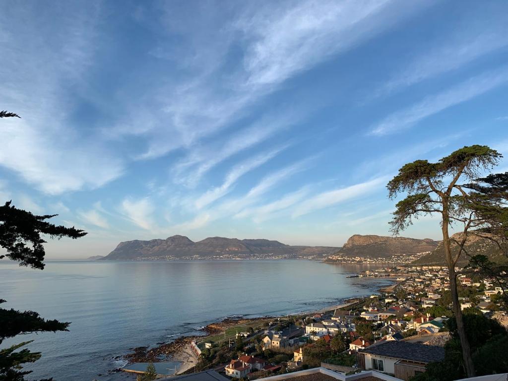 a view of a beach with a city and mountains at Spindrift in Kalk Bay