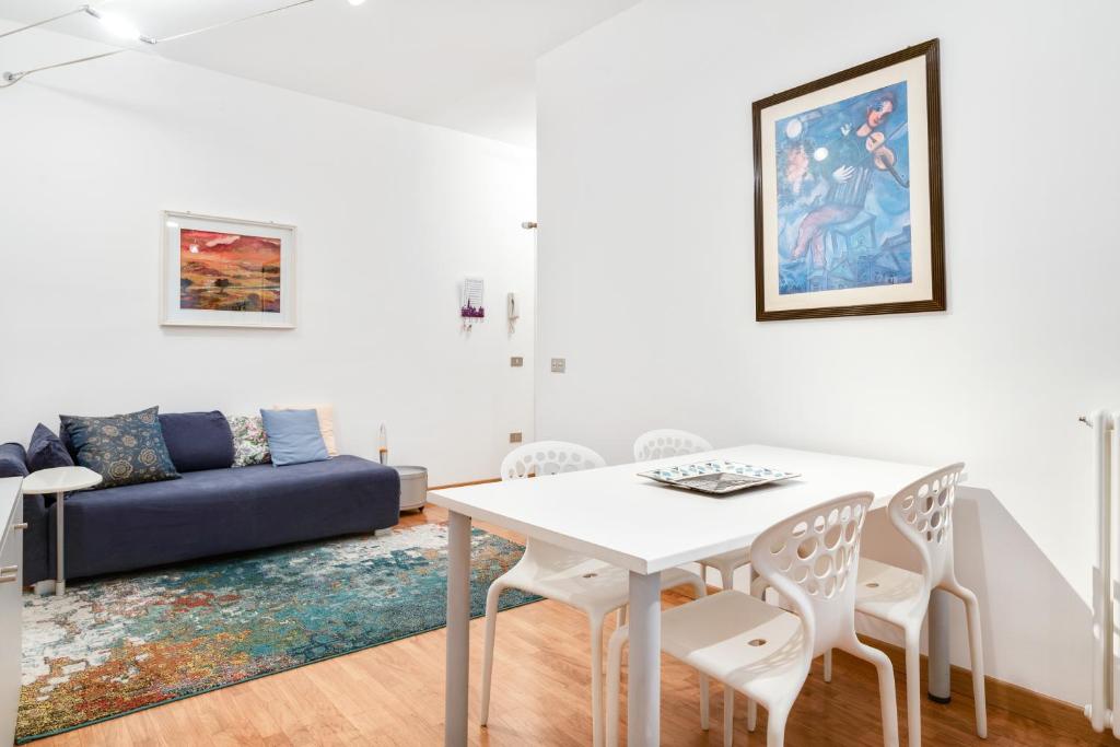 ein Wohnzimmer mit einem Tisch, Stühlen und einem Sofa in der Unterkunft Ospedale & Galleria Ognissanti Apartment in Padua