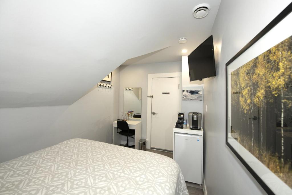 a small room with a bed and a kitchen at Serene Niagara Inn in Niagara Falls