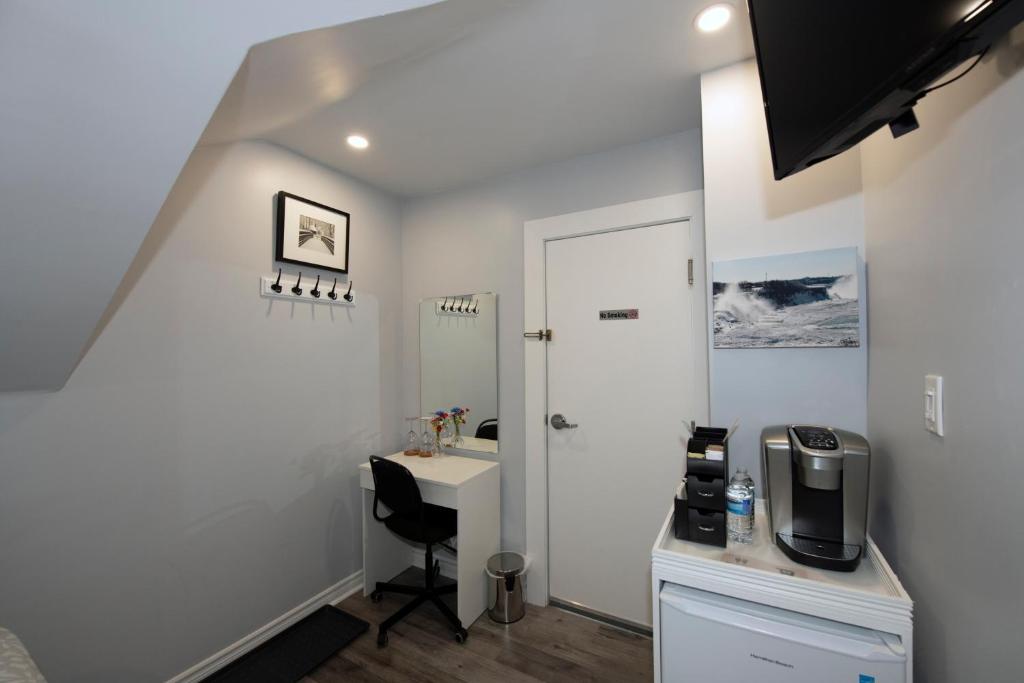 a room with a desk and a sink in a room at Serene Niagara Inn in Niagara Falls