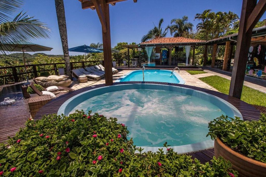 una piscina con patio y una casa en Pousada Molinha, en Penha