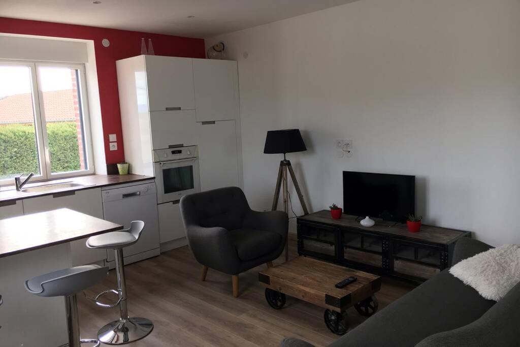 een woonkamer met een stoel, een televisie en een tafel bij Gîte de chenieux in Saint-Victor-sur-Loire