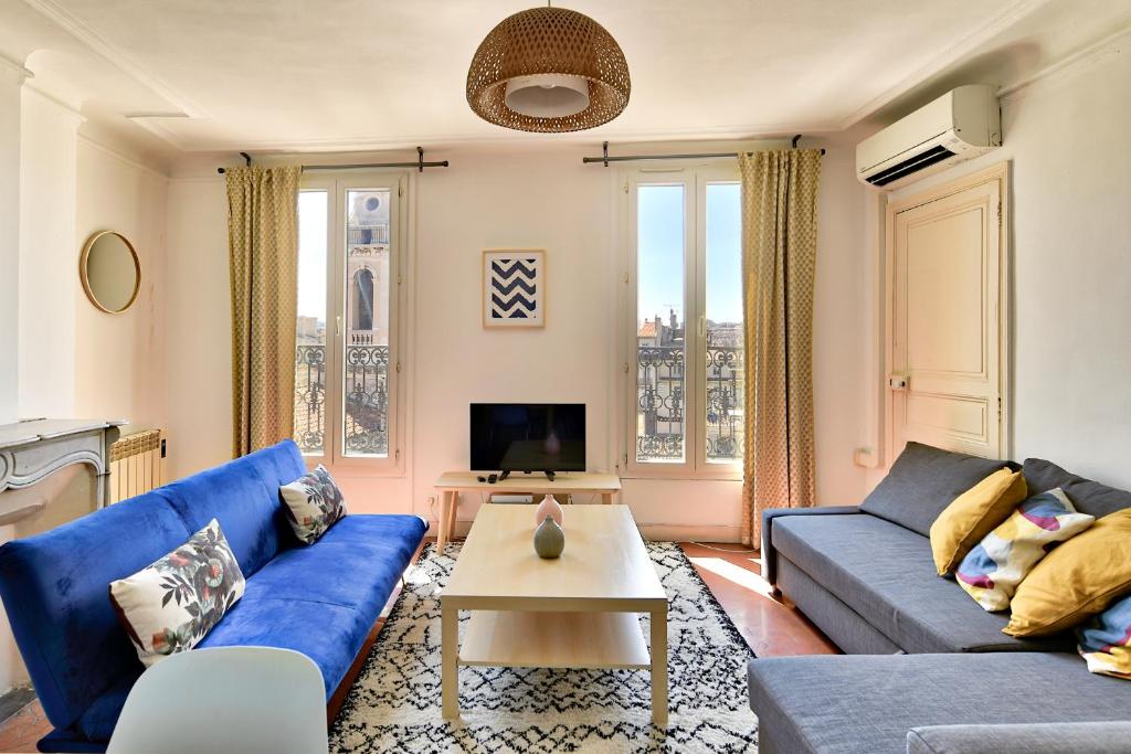 un salon avec des canapés bleus et une télévision dans l'établissement NOCNOC - Le Republique, à Marseille