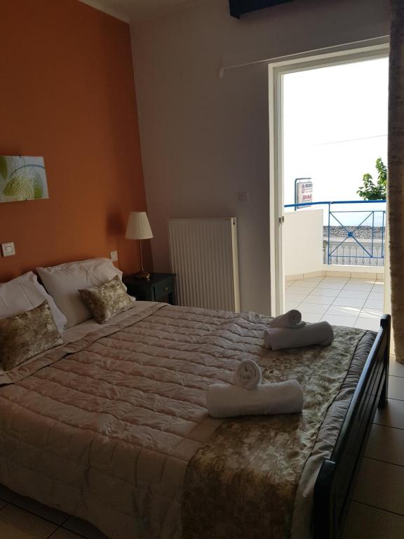 a bedroom with a large bed with two towels on it at Schinas Apts. in Vitrinítsa