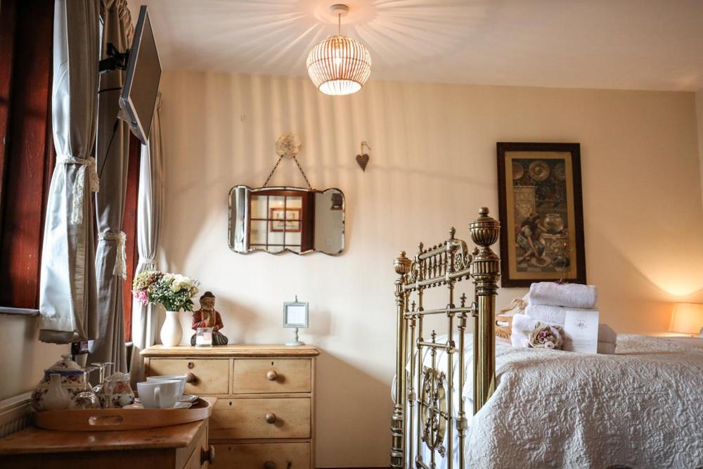 a bedroom with a bed and a dresser and a lamp at The Shepherd's Purse in Whitby