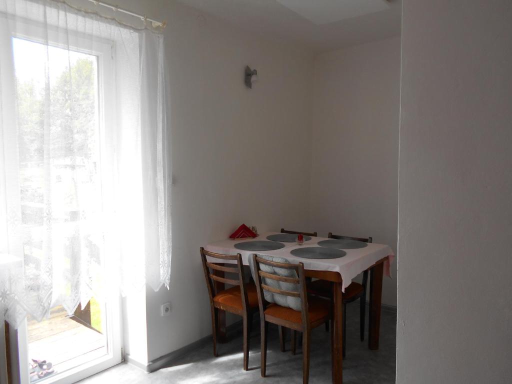 um quarto com uma mesa com cadeiras e uma janela em Ubytování ve Frýdku em Frýdek-Místek
