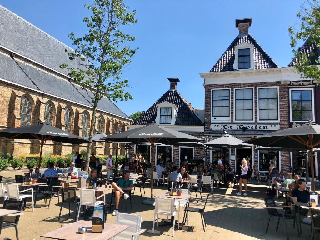 un grupo de personas sentadas en mesas frente a un edificio en Hotel Grandcafe De Doelen, en Franeker