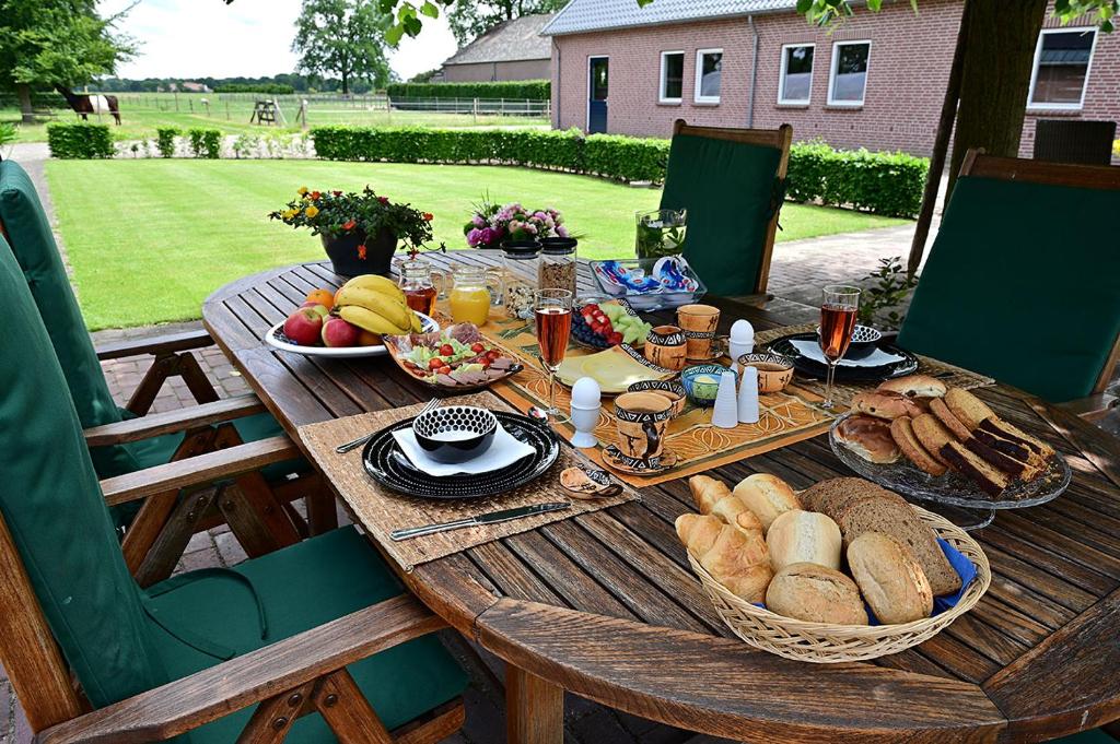 einen Holztisch mit Essen und Brot darauf in der Unterkunft De Lakenvelder B&B Eersel in Eersel