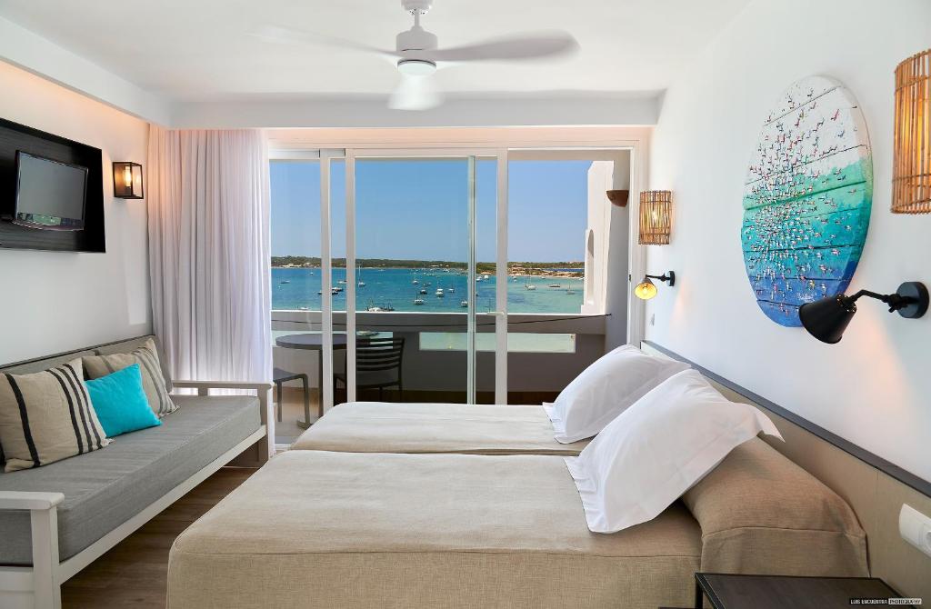 una camera con due letti e vista sull'oceano di Apartamentos Sabina Playa a La Savina