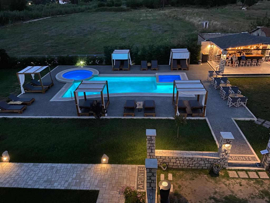 an overhead view of a pool with tables and chairs at A Ponte Studios & Apartments in Sykia Chalkidikis