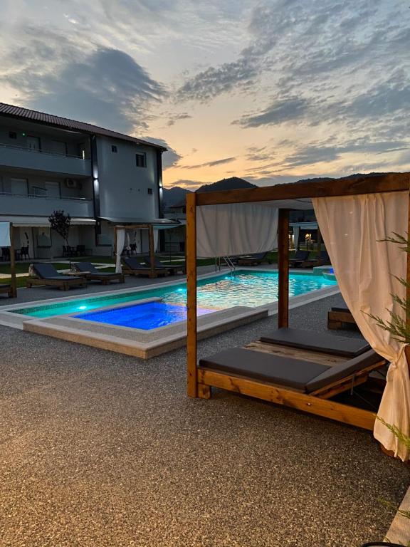 a swimming pool with a bed and a building at A Ponte Studios & Apartments in Sykia Chalkidikis