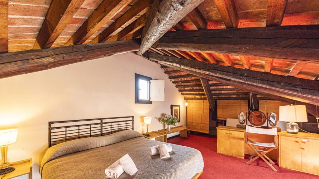a bedroom with a large bed and wooden ceilings at Penthouse Accademia in Venice