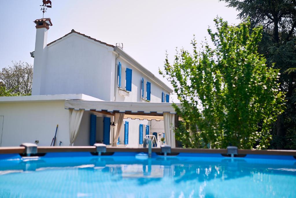 a house and a swimming pool in front of a house at Cà del Mar rustico a Jesolo con giardino e piscina privati ad uso esclusivo # in Jesolo