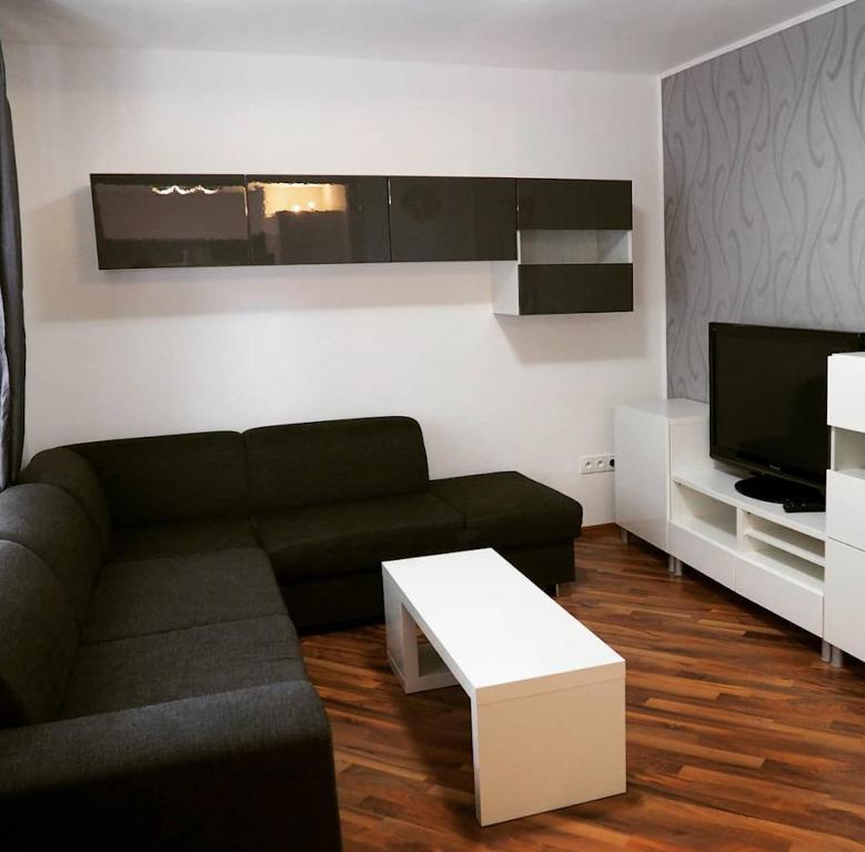 a living room with a couch and a tv at Apartmán 224 in Mikulov