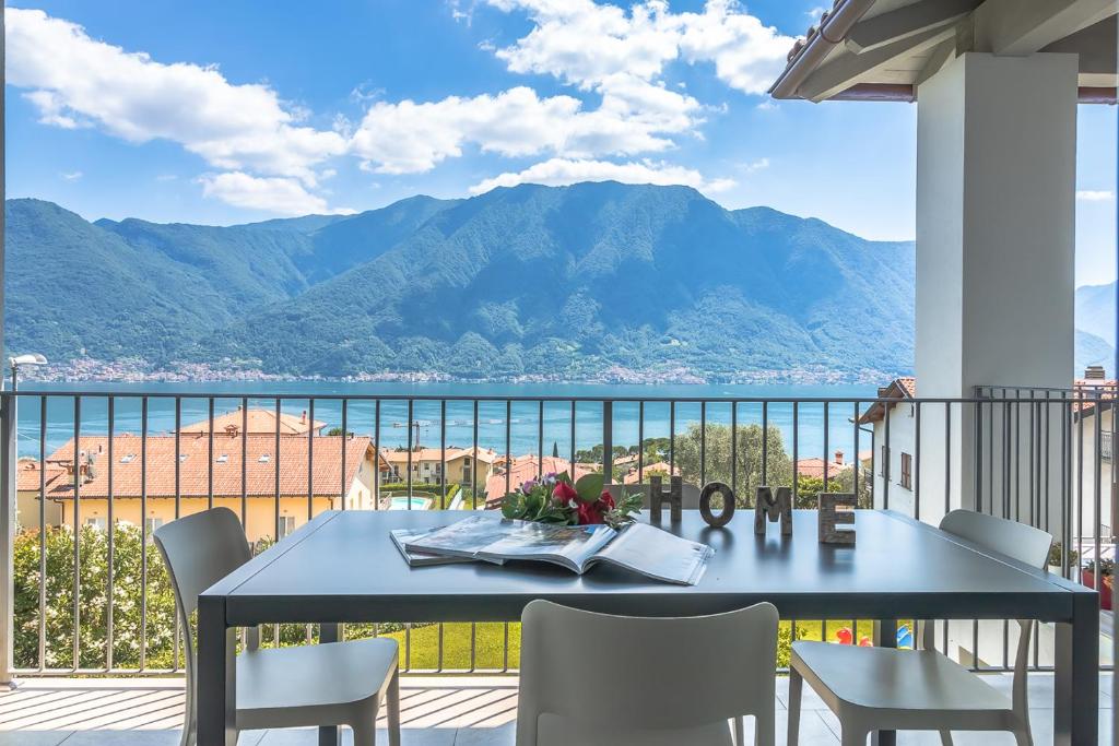 een tafel en stoelen op een balkon met uitzicht op de bergen bij Apartment Sant Agata-6 - Tremezzina in Ossuccio