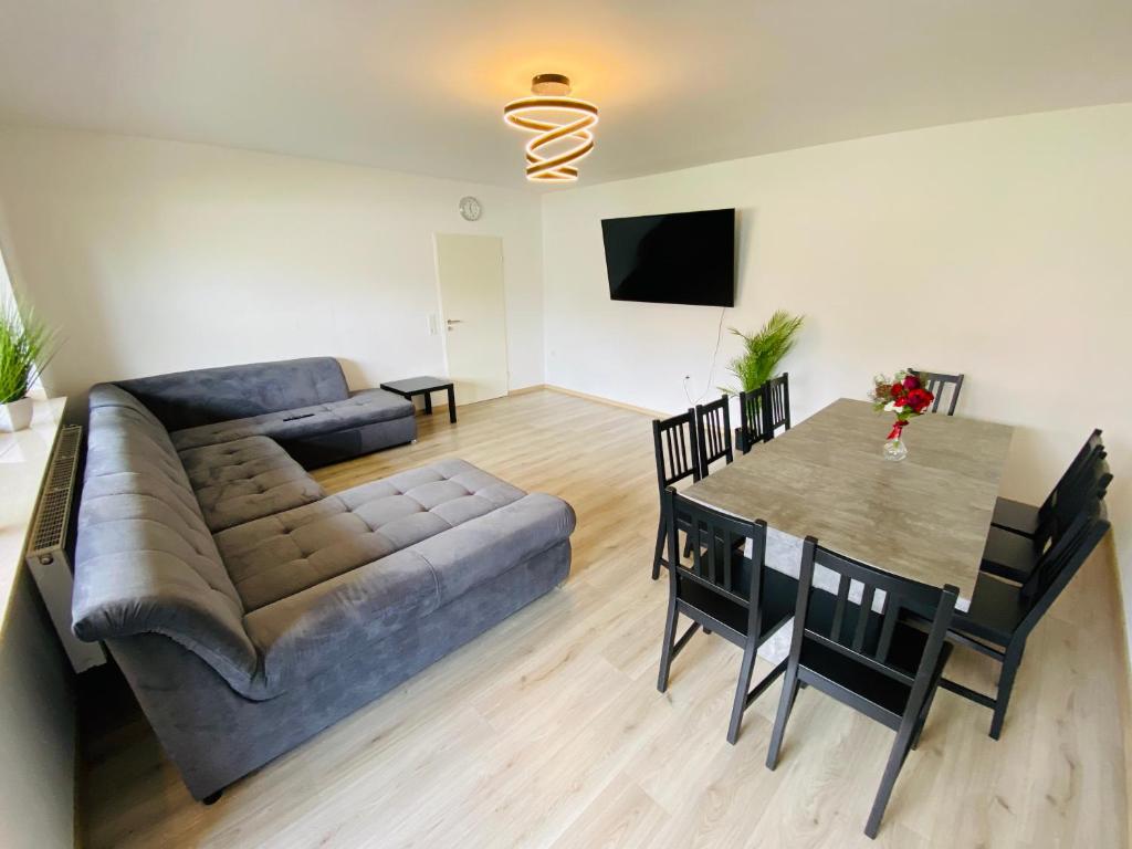 uma sala de estar com um sofá e uma mesa em Generous Apartment with own parking Space em Paderborn