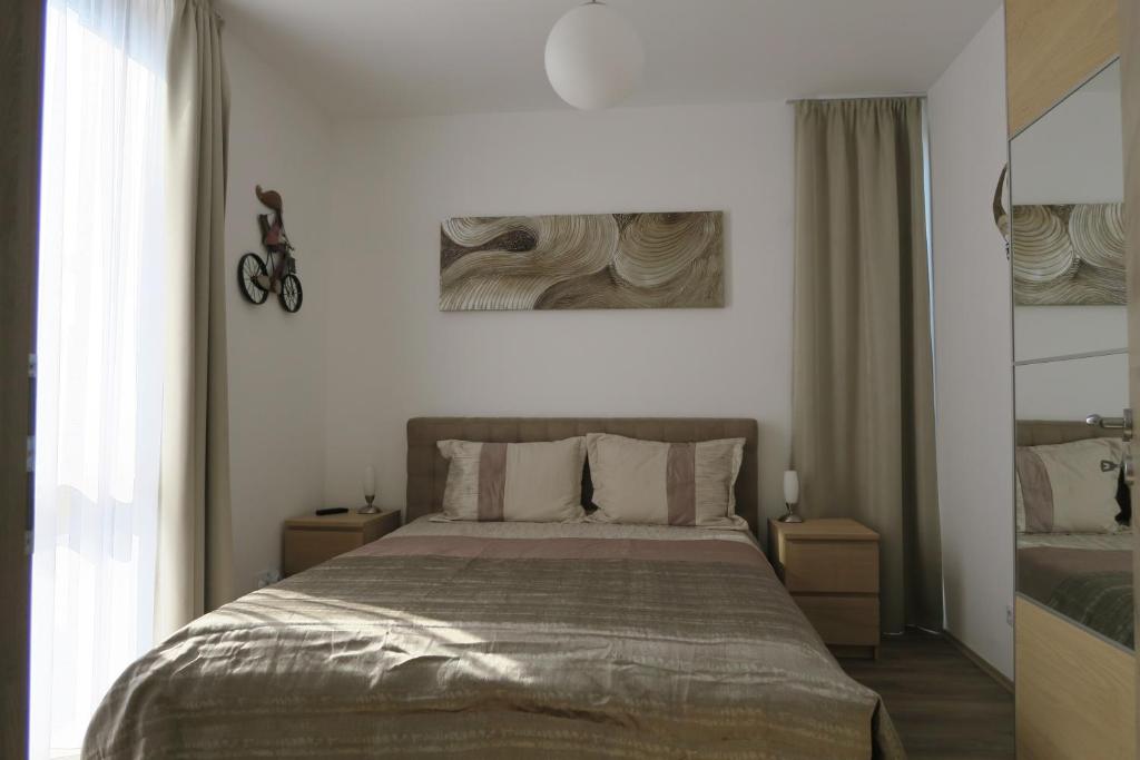 een slaapkamer met een groot bed en 2 ramen bij Port Apartman Siófok in Siófok