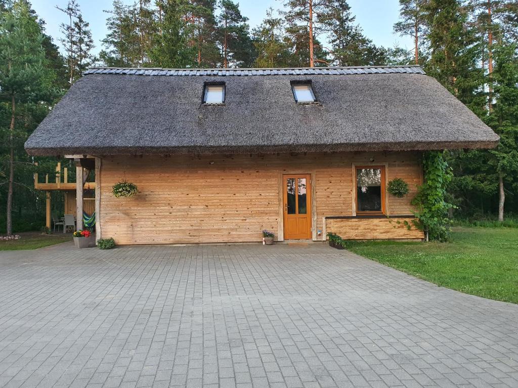 een klein houten gebouw met een dak op een oprit bij Rīti Siguldā in Stīveri
