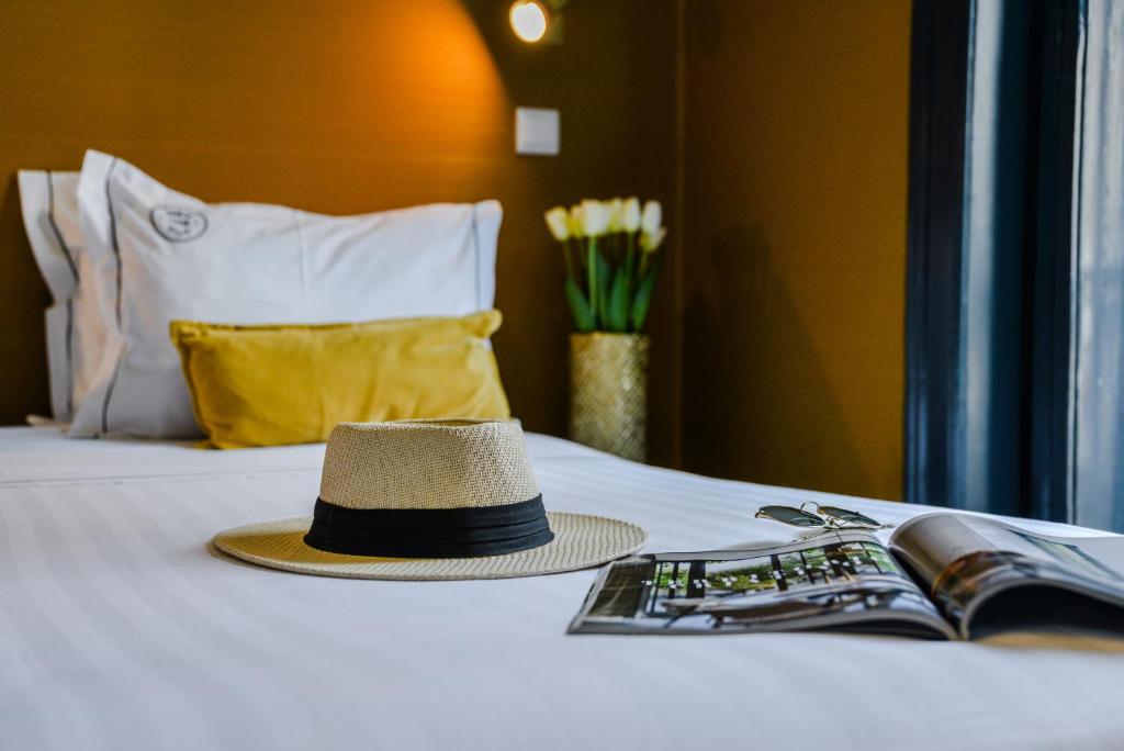 a hat is sitting on top of a bed at Santa Luzia B&B - HOrigem in Lisbon