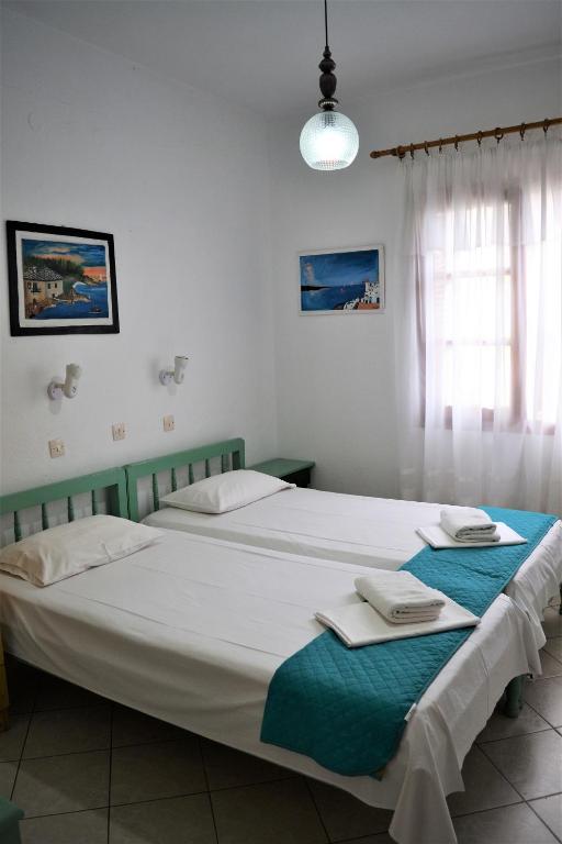 a bedroom with two beds with towels on them at Evaggelou Rooms in Potos